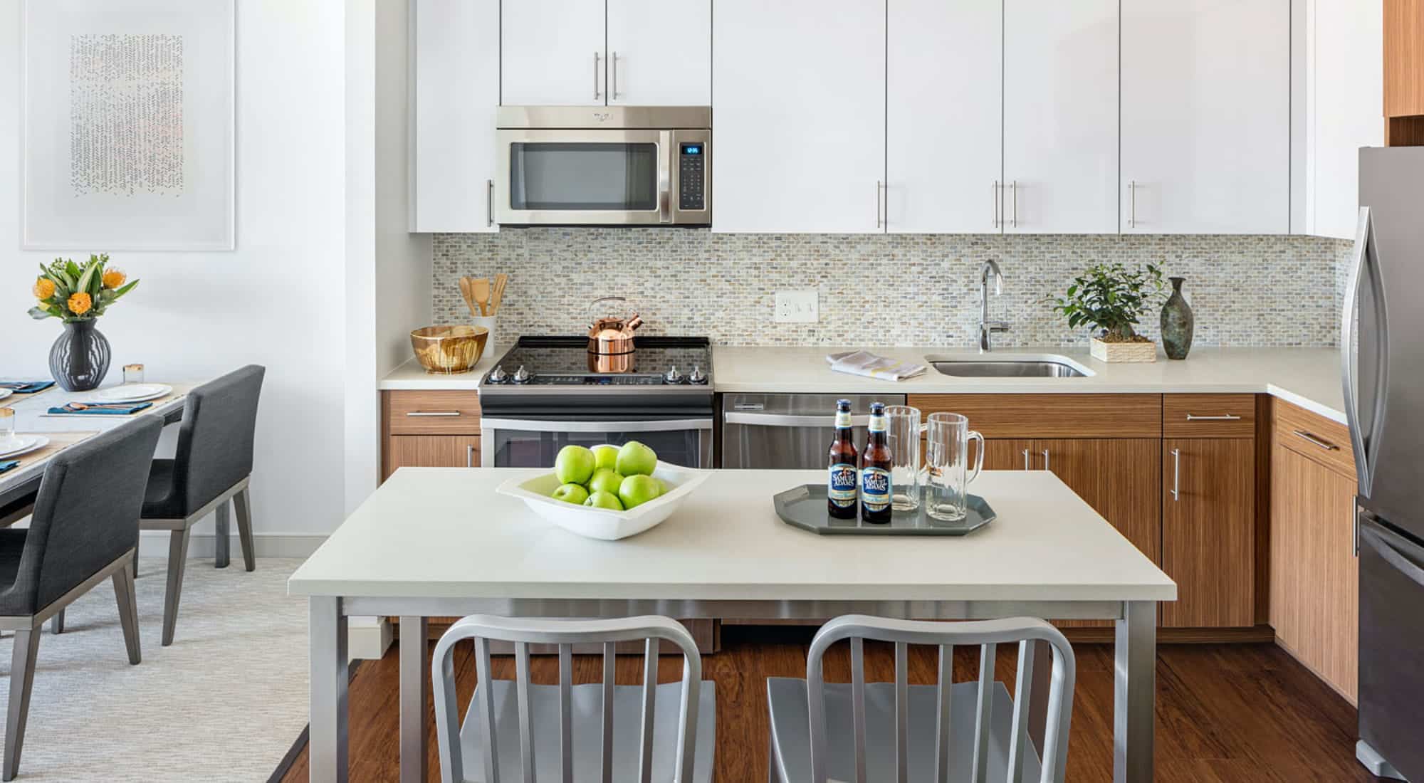 Kitchen with white cabinets and white table in the middle with two chairs